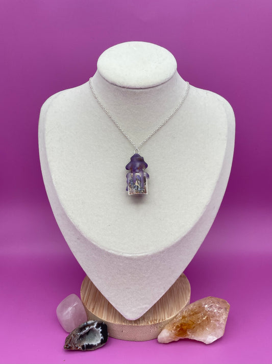 Peace spell jar Necklace sealed with purple wax on a white mannequin bust against a purple background